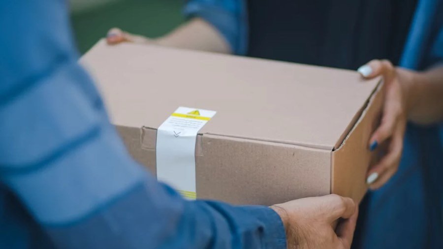 Coursier moto remettant un colis urgent en main propre à sa destinataire