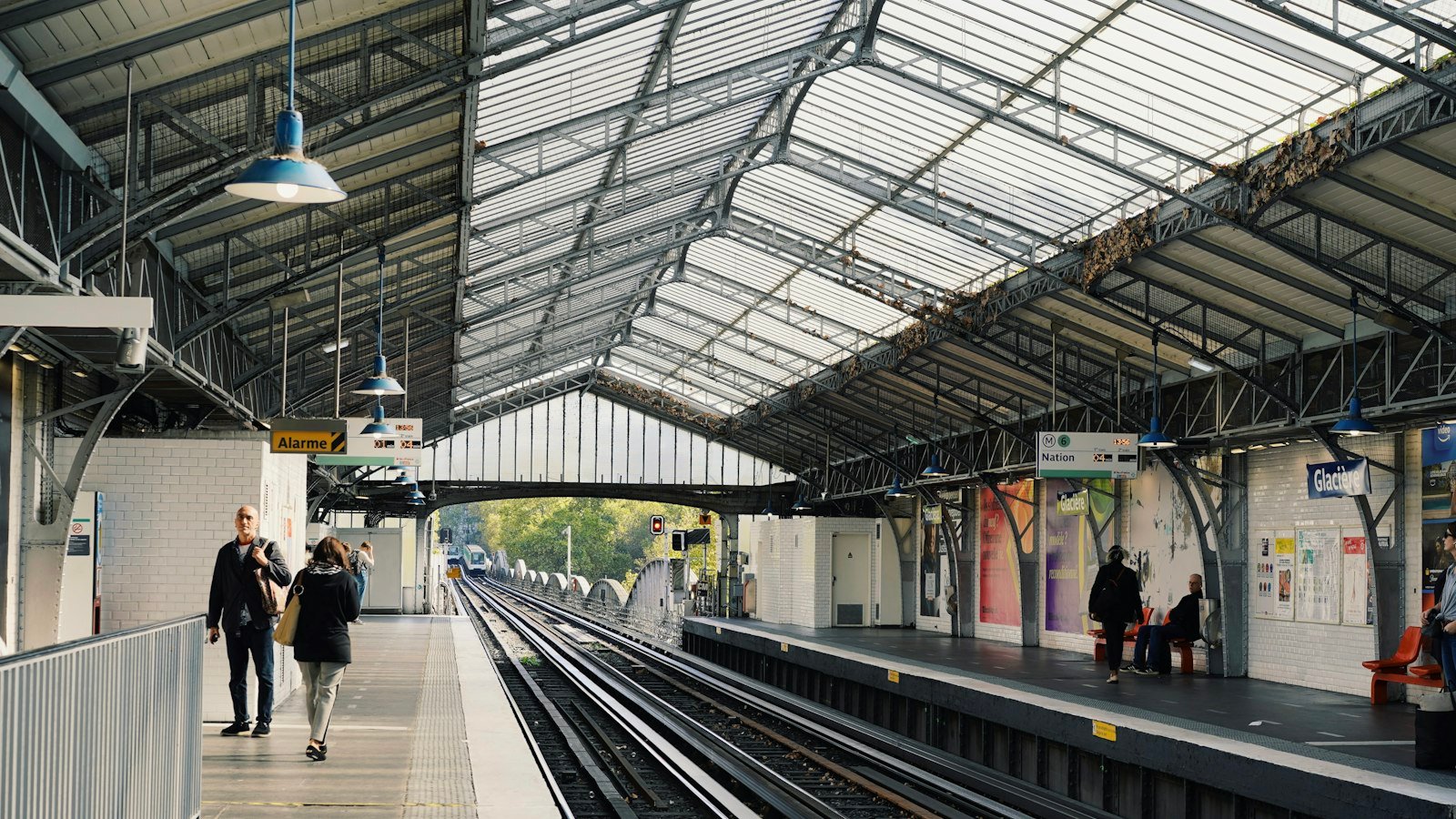 Hall de gare sous verrière, voyageurs marchant sur le quai