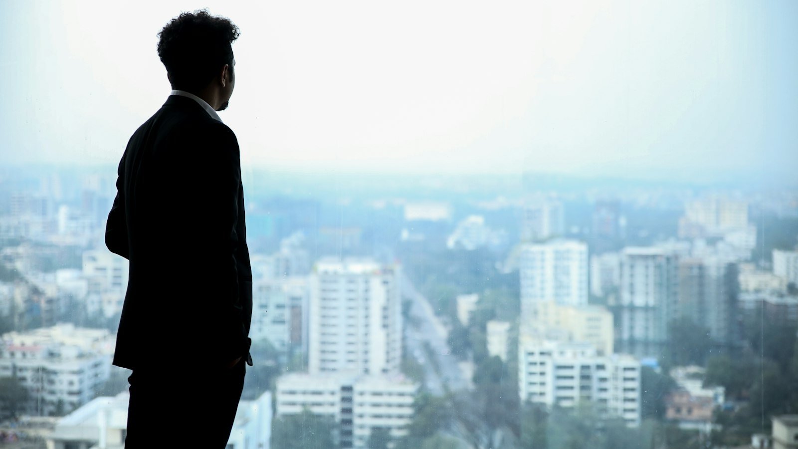 Homme en costume regardant la ville depuis un toit